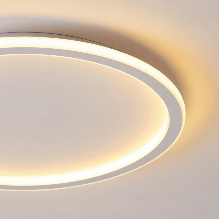 Close-up van een deel van de lichtring met de witte rand, die een warme gloed op het plafond werpt. 2