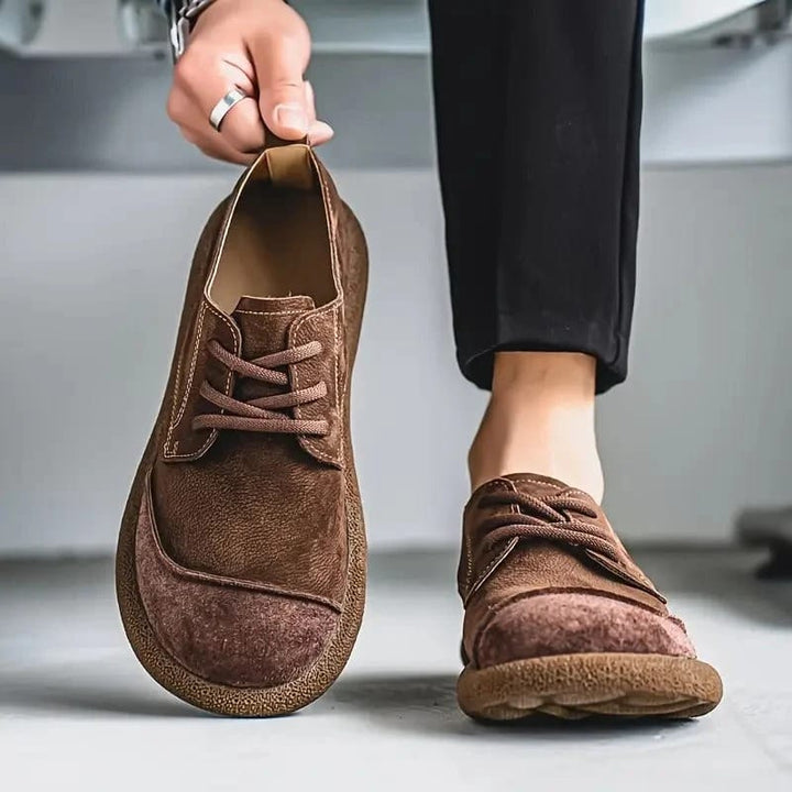Donkerbruine veterschoenen: één schoen hangt in de hand aan de hielstrook, de andere wordt gedragen bij een zwarte broek. 8