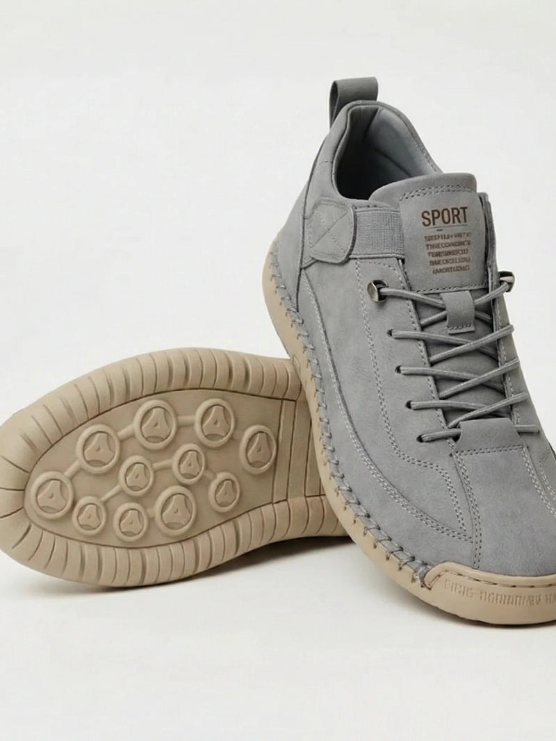 Grijze suÃ¨de instapper met elastische veters, naast een schoen met beige zool met noppenprofiel 17