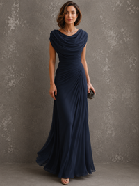 Model in dezelfde jurk in donkerblauw, vooraanzicht met gedrapeerde halslijn en vloerlange rok, clutch in de hand. 2
