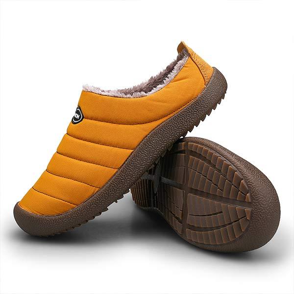 Oranjegele pantoffel van opzij naast een omgekeerde pantoffel die de bruine profielzool met grip laat zien 15