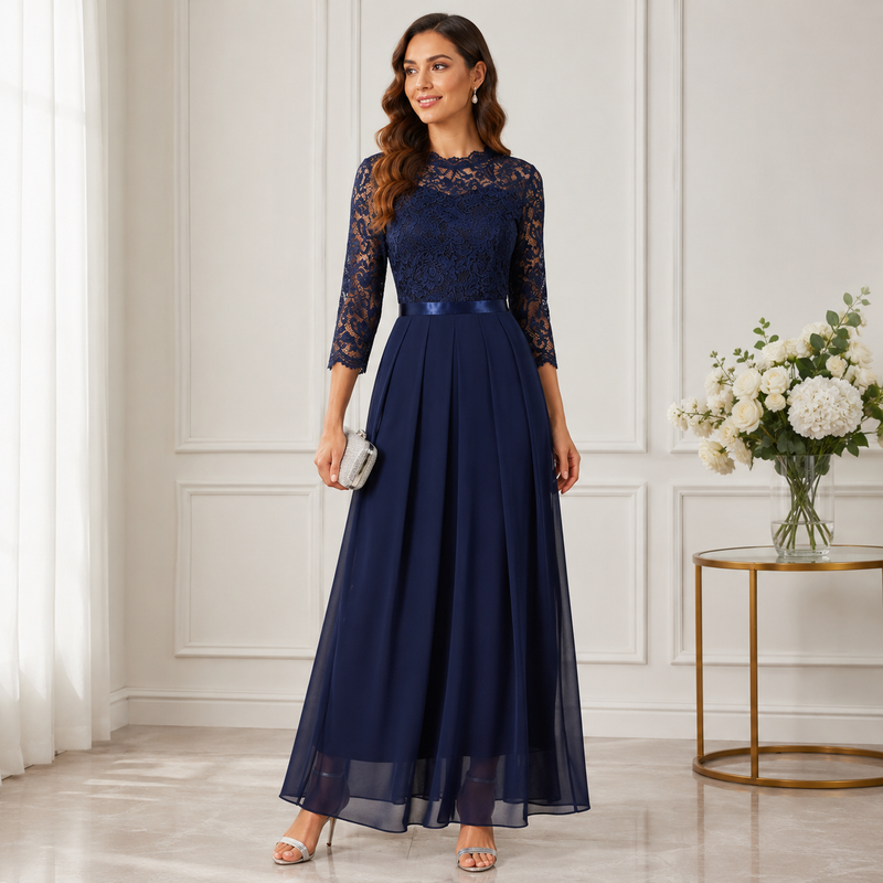 Model draagt de donkerblauwe jurk met kanten bovenstuk en vloeiende chiffon rok, met een zilverkleurig clutchtasje in de 2
