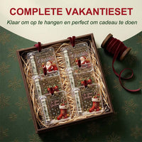 Doos met stro waarin zes hangers met verschillende kerstmotieven liggen, naast een klosje rood fluwelen lint. 7