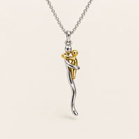 Zilverkleurige schakelketting met hanger van twee omhelzende figuurtjes, een zilverkleurig groot en een goudkleurig klein, vooraanzicht op een crèmekleurige ach 1