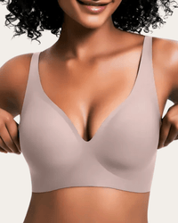 Model draagt de effen beha in lichte taupe, voorkant, met gladde cups en diepe V-hals. 10