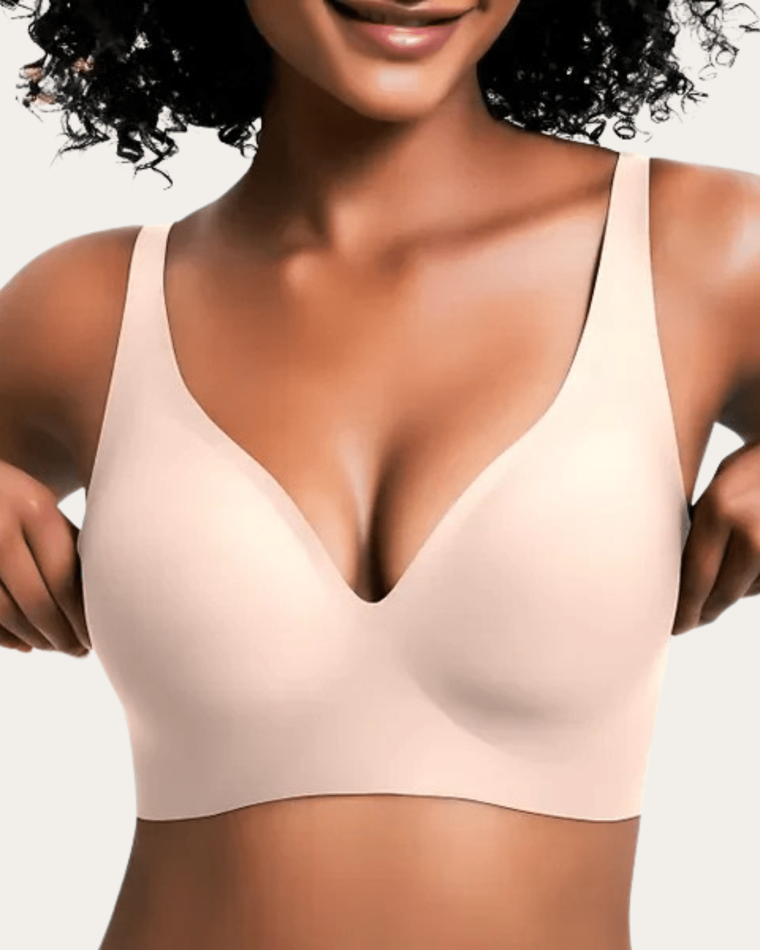 Model draagt de effen beha in zachte huidtint beige, voorkant, met naadloze afwerking en diepe V-hals. 6