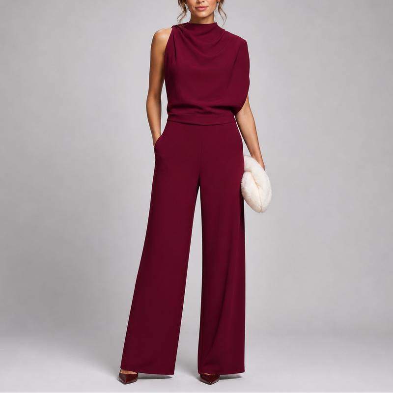 Model draagt de jumpsuit in bordeauxrood met gedrapeerd bovenstuk en wijde pijpen, met pluchen clutch 7