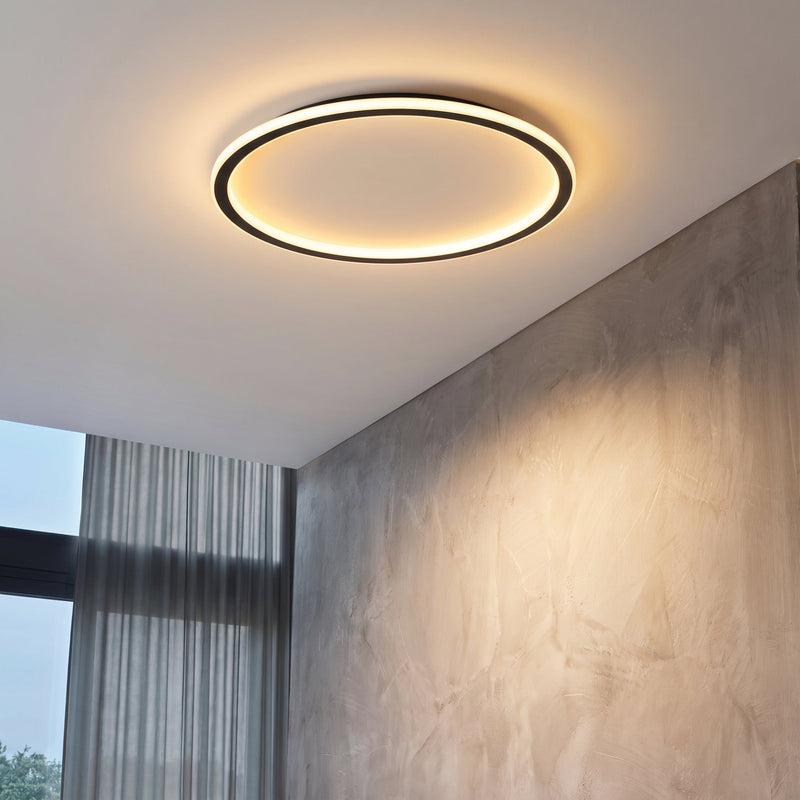 Brandende ringlamp aan het plafond van een kamer met grijs gestuukte wand en een gordijn voor het raam. 3