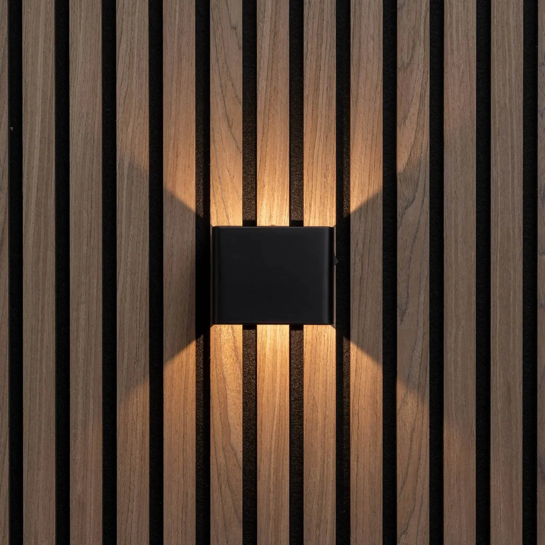 Zwarte wandlamp recht van voren op houten lamellenwand, met warm licht omhoog en omlaag 5