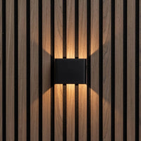 Zwarte wandlamp recht van voren op houten lamellenwand, met warm licht omhoog en omlaag 5