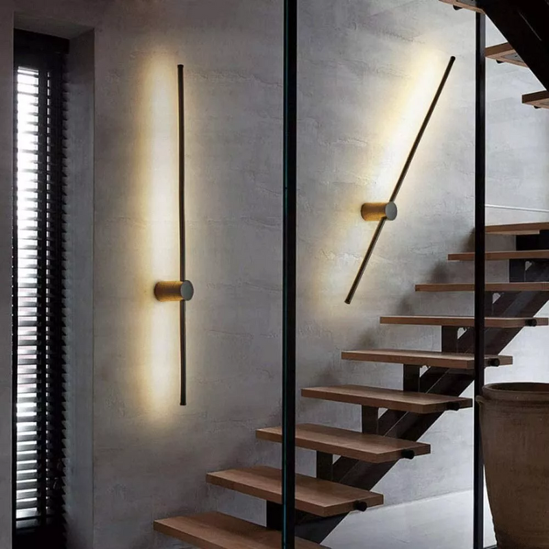 Twee zwarte lichtstaven op een grijze betonnen muur naast een houten trap, één verticaal en één schuin gedraaid. 4
