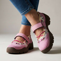 Roze suÃ¨de schoenen met felroze elastische veters, ruitjesstof en bruine profielzool, gedragen met jeans in de studio. 4