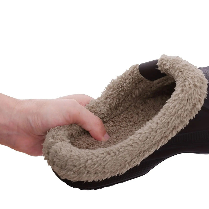 Hand voelt in de zachte beige pluchen binnenkant van een donkere klomp, die de dikke voering laat zien. 5