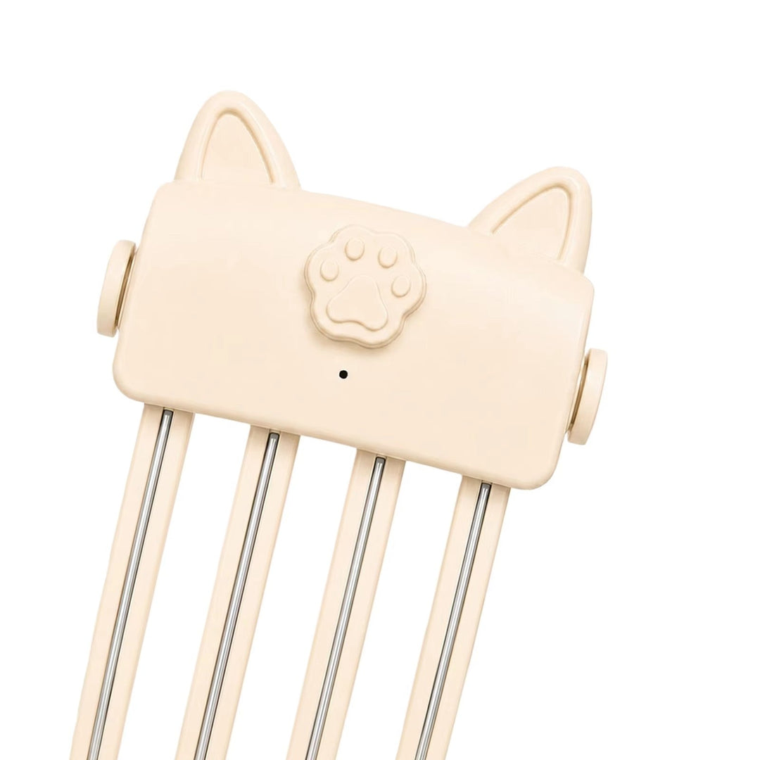 Schuin close-up van de crèmekleurige styler met kattenoren, pootjesknop en metalen strips in de tanden 8