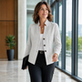 Vrouw loopt in een lichtgrijze, bijna witte blazer met kabel- en ruitstructuur, witte top en zwarte pantalon. 9