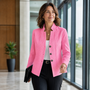 Vrouw loopt met een map onder de arm in een felroze blazer met kabelstructuur en drie knopen. 8