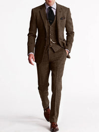 Model draagt het pak in donkerbruin tweed met vest, zakketting en bruine monkstrap-schoenen 3