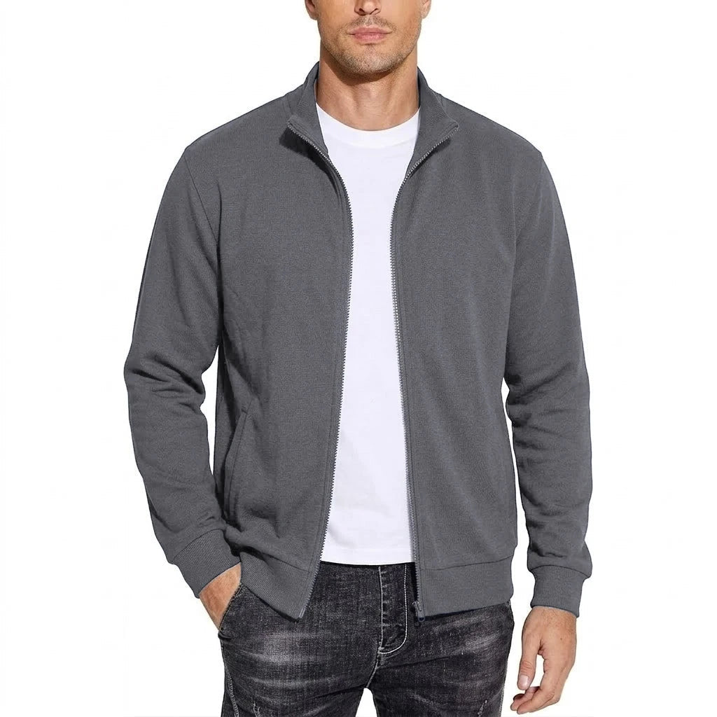 Model draagt de donkergrijze sweatshirtjack open over een wit T-shirt, met opstaande kraag, ribboorden en één hand in de zak. 5