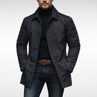 Model draagt de zwarte jas met donkere knopen over een zwarte coltrui, jeans en bruine riem. 4
