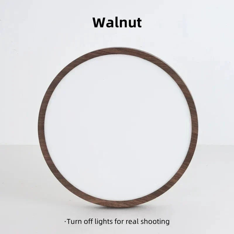 Voorkant van de uitgeschakelde ronde lamp met donkere houtlook rand en wit diffuser, rechtopstaand tegen een lichte achtergrond. 17