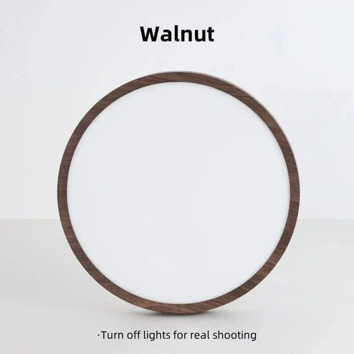 Voorkant van de uitgeschakelde ronde lamp met donkere houtlook rand en wit diffuser, rechtopstaand tegen een lichte achtergrond. 17