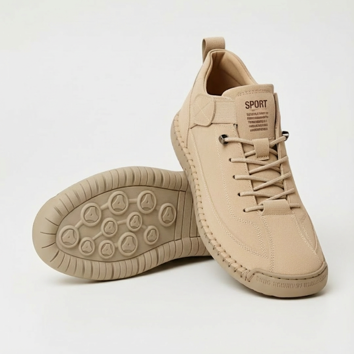 Beige sneaker met veters en elastische band, met een tweede schoen ernaast waarvan de profielzool met ronde noppen zichtbaar is. 1