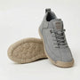 Lichtgrijze sneaker met grijze veters en beige zool, naast een schoen waarvan de zool met ronde noppen te zien is. 8