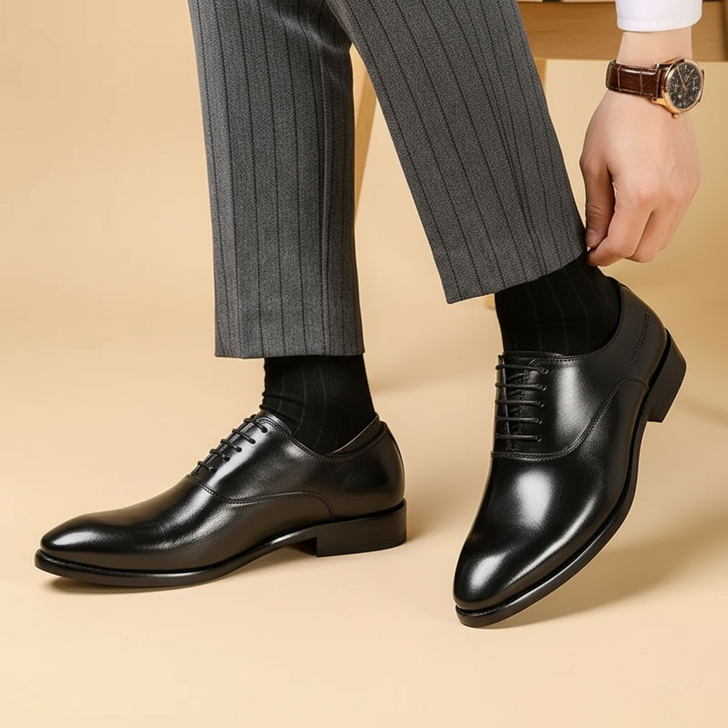 Zwarte leren veterschoenen gedragen met gestreepte broek terwijl een model de broekspijp vasthoudt, schuin vooraanzicht 3