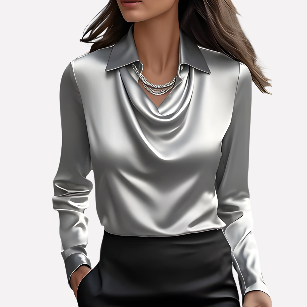 Vrouw draagt de blouse in zilvergrijs met een zwarte rok en twee zilveren kettingen 8