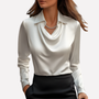 Vrouw draagt de blouse in wit met een zwarte rok en een zilveren ketting 1