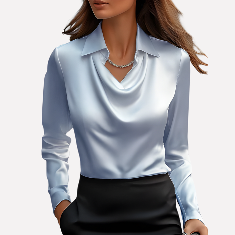 Vrouw draagt de blouse in lichtblauw met een zwarte rok en een zilveren ketting 6