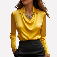 Vrouw draagt de blouse in geel met een zwarte rok en een opvallende statement-ketting 10