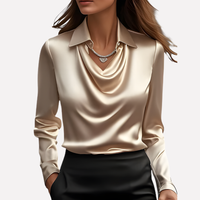 Vrouw draagt de blouse in champagnekleur met een zwarte rok en een hanger aan de ketting 5