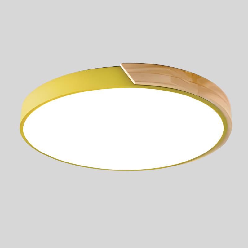 Gele ronde plafondlamp met houten accent langs een deel van de rand, los afgebeeld op lichtgrijze achtergrond. 15