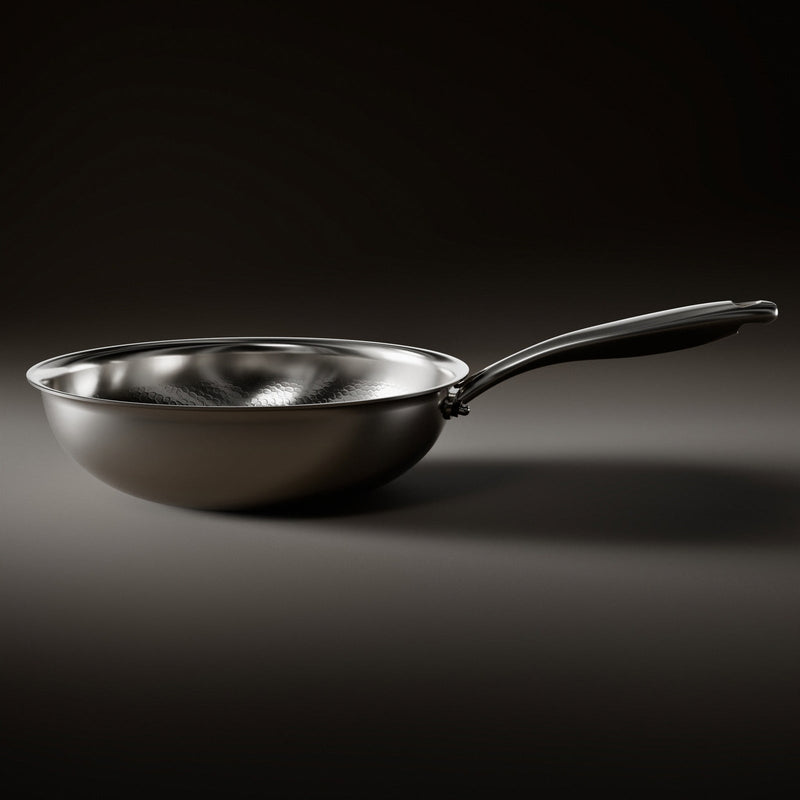 Zijaanzicht van de wokpan met gladde, gebogen buitenkant en lange metalen steel, met het gehamerde oppervlak aan de binnenkant zichtbaar. 2