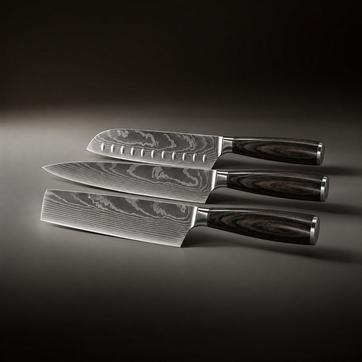 De drie messen naast elkaar liggend van boven naar beneden, met een santoku met kuiltjes, een koksmes en een hakmes. 2