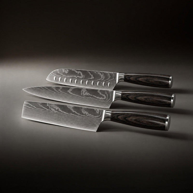 De drie messen naast elkaar liggend van boven naar beneden, met een santoku met kuiltjes, een koksmes en een hakmes. 2
