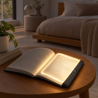 Verlichte leeslamp op een opengeslagen boek op een houten salontafel, met een slaapkamer op de achtergrond 7