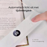 Vinger drukt op de timerknoppen van de lamp op een boek, met het cijferdisplay zichtbaar 9