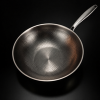 Wokpan van bovenaf gezien, met het gehamerde schubbenpatroon in de binnenkant goed zichtbaar en de steel rechtsboven. 2