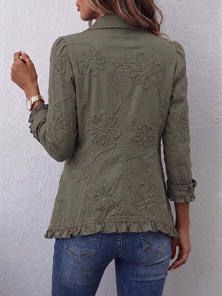 Achterkant van de groene jas met geborduurde bloemen en ruches langs de onderrand, gedragen met jeans 3