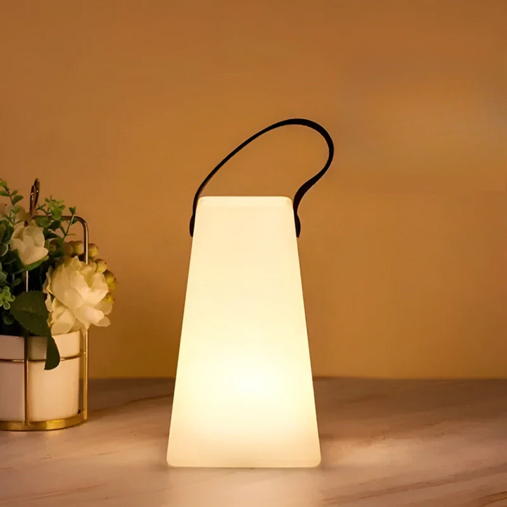 Conische lamp met zwarte lus, warm brandend naast een witte bloemenpot op een tafel 11