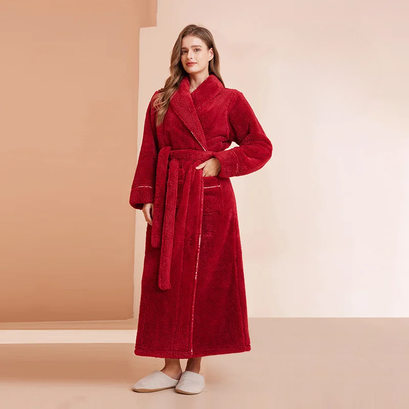 Model in rode badjas met lange ceintuur, één hand in de zak, in een beige ruimte 7