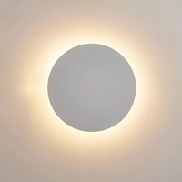 Close-up van de witte uitvoering: lichte ronde schijf met zachte warmwitte gloed op de muur 3