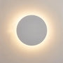 Close-up van de witte uitvoering: lichte ronde schijf met zachte warmwitte gloed op de muur 3