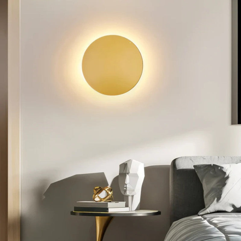 Gouden ronde wandlamp aan de muur boven een bijzettafeltje naast een bed in de slaapkamer 6