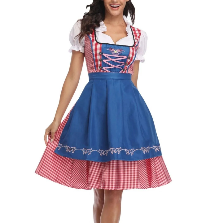 Model draagt de dirndl met felblauwe schort, rood-wit geruite rok en lijfje met roze veters en pofmouwen, vooraanzicht. 3
