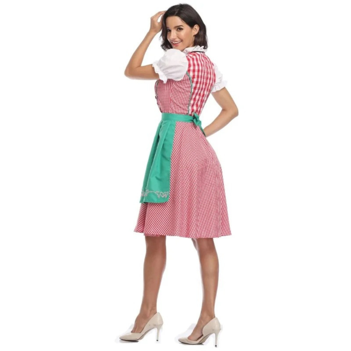 Achteraanzicht van de roze-wit geruite dirndl met groene schort en strik op de rug, model kijkt glimlachend om. 10