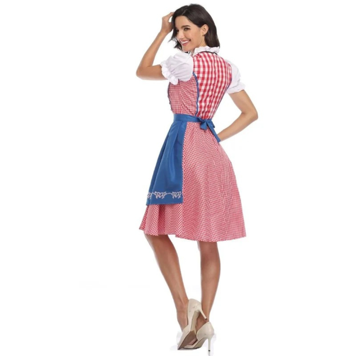 Achteraanzicht van de rood-wit geruite dirndl met felblauwe schortstrik, model kijkt lachend over haar schouder. 9