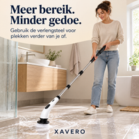 Vrouw in beige trui en spijkerbroek schrobt met de lange steel een schuimende badkamervloer naast de douche 8